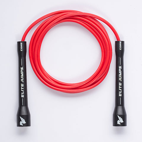 A red jump rope with black handles, coiled in a circle on a white background. The handles are printed with the brand name 'ELITE JUMPS' and 'CORE' in white text.